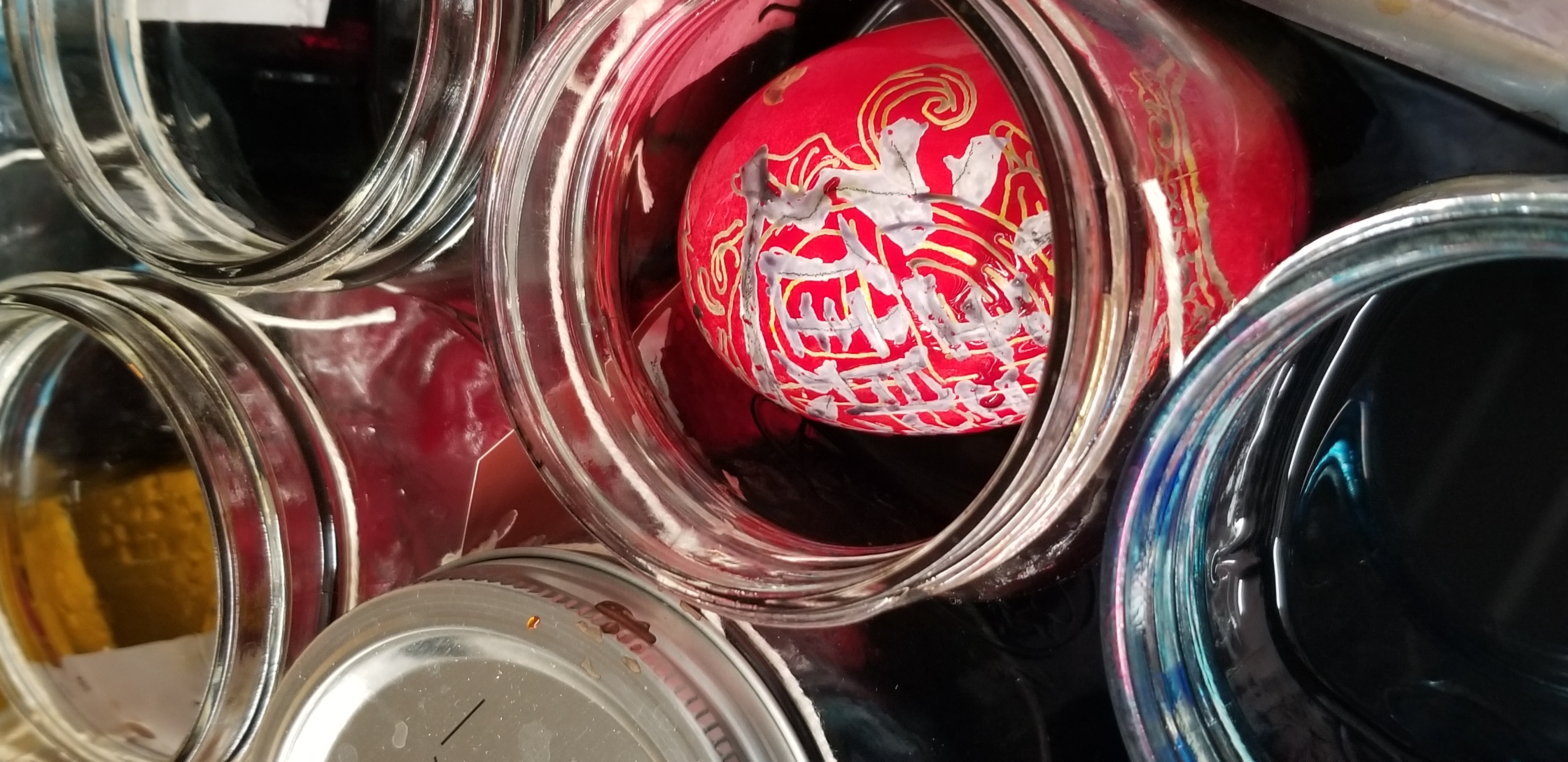 student decorates egg with Chinese symbol for fortune